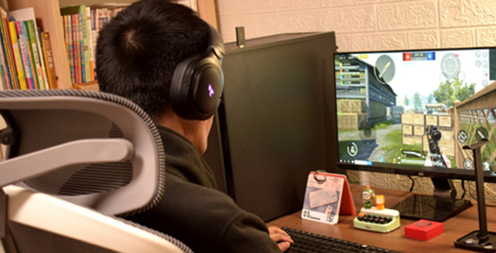 Player using a SOMIC G710 headset at a gaming desk